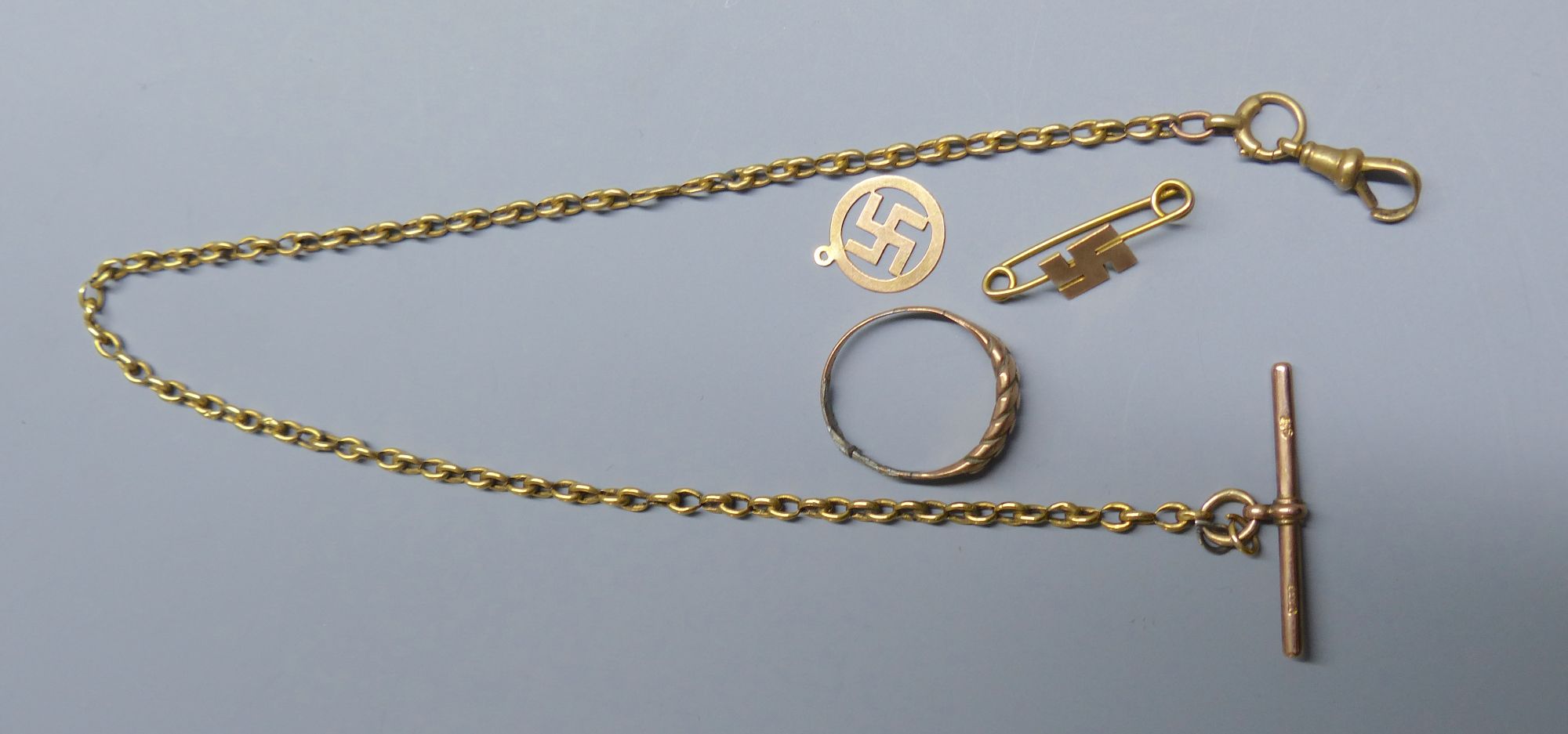 An 18ct albert chain with a 9ct T-bar, 35cm, gross 7.6 grams, together with a 9ct ring and two 9ct gold charms, gross 4.7 grams.